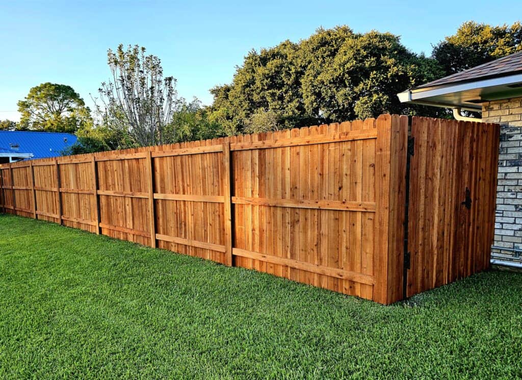 Freshly installed pre-stained wood fence with rich color and clean finish in Lafayette, Louisiana